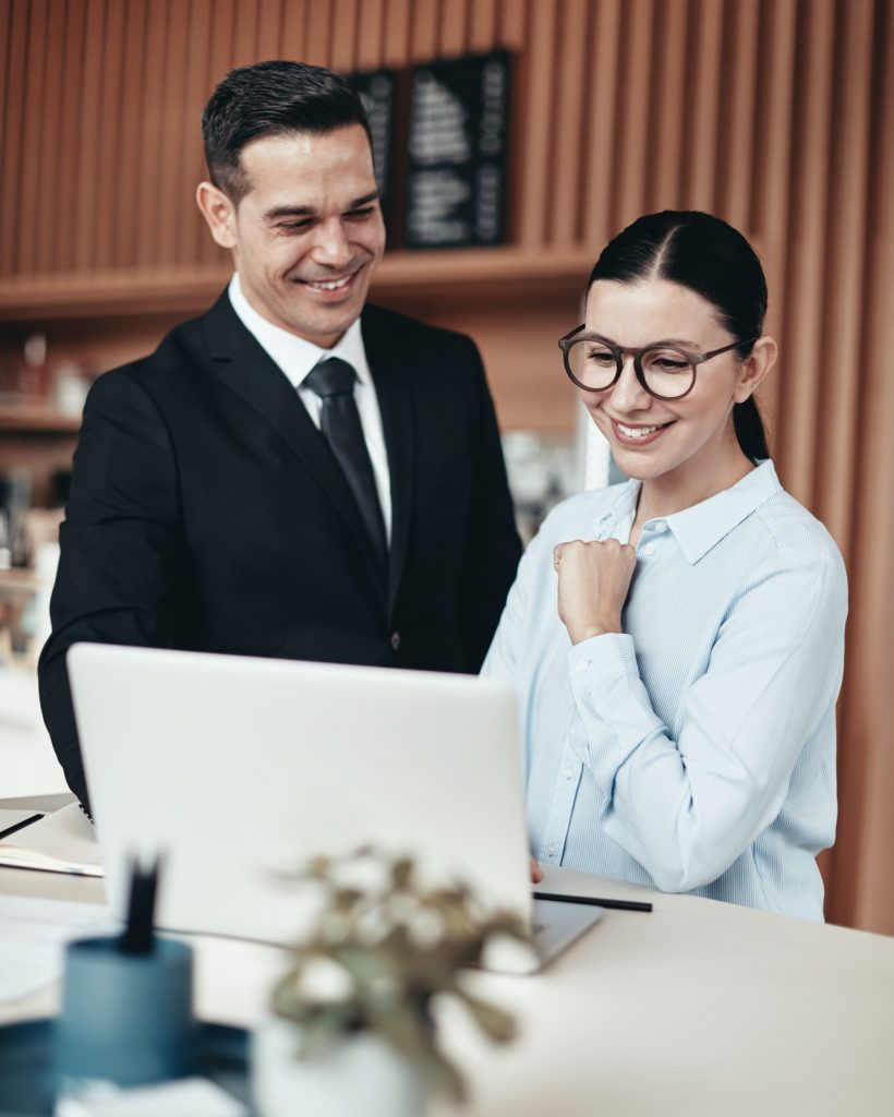 two-smiling-businesspeople-using